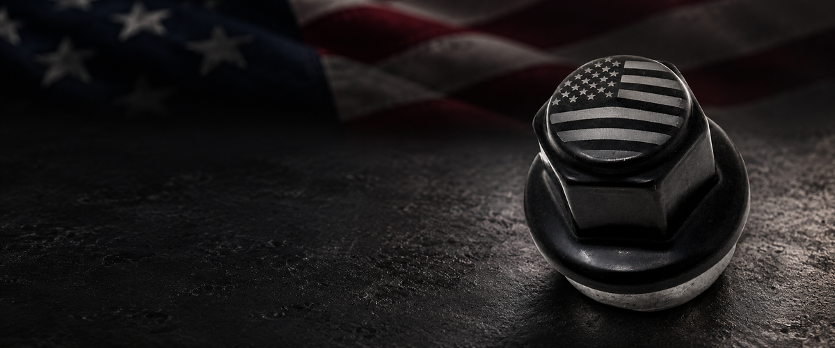 Black lug nut with a laser-etched American flag against a dark American flag-inspired background.